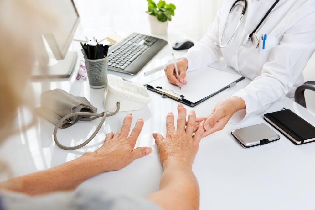 gydytojas apžiūri artrozės rankas
